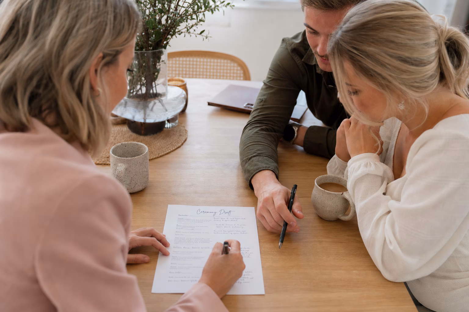 Couple and celebrant reviewing a personalised wedding ceremony draft