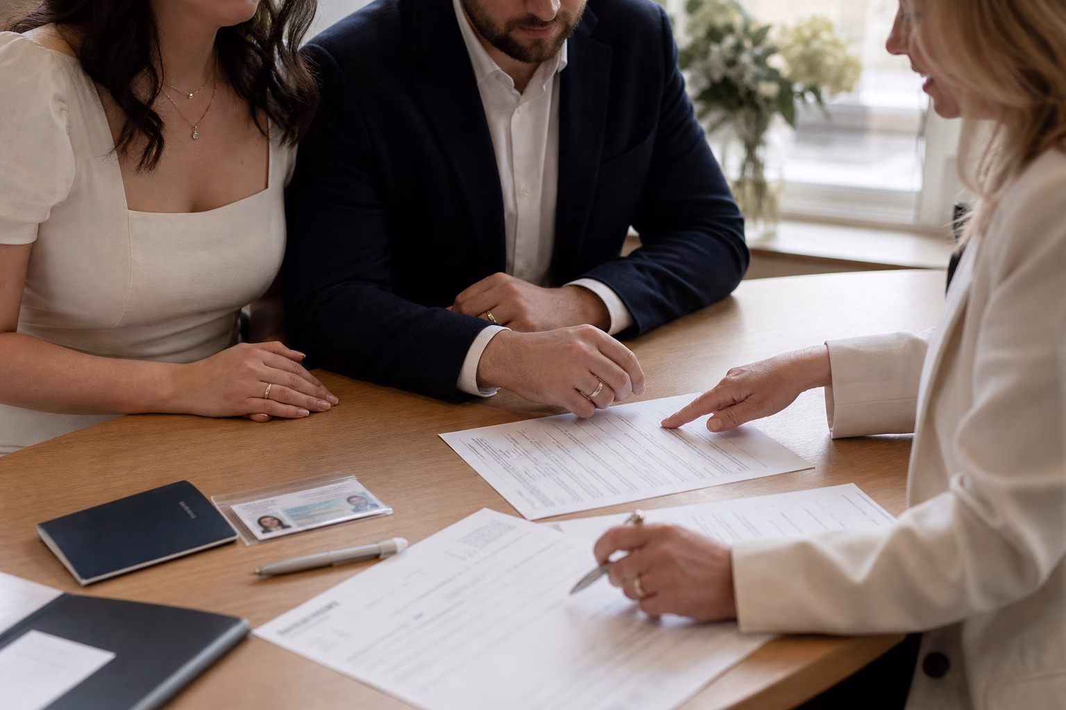 Couple and celebrant review marriage documents at a table