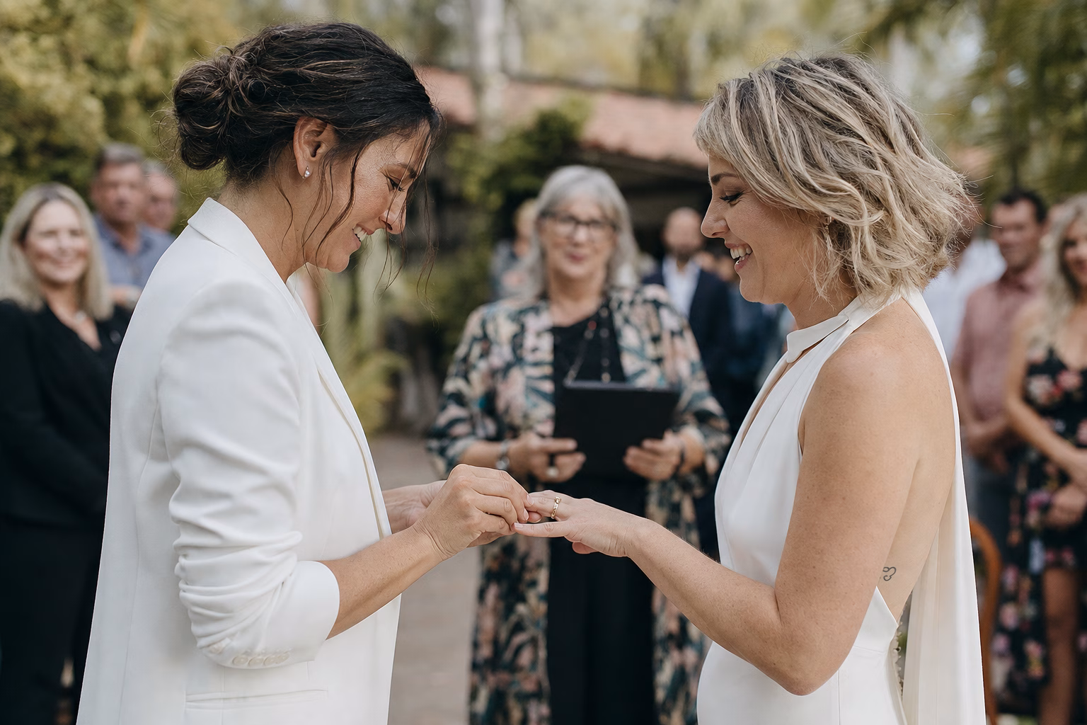 Partners exchanging rings during an intimate outdoor commitment ceremony