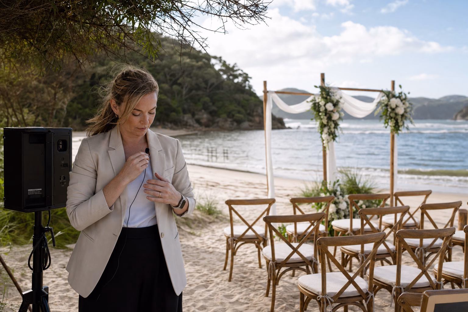 Celebrant testing sound equipment at an outdoor beach ceremony